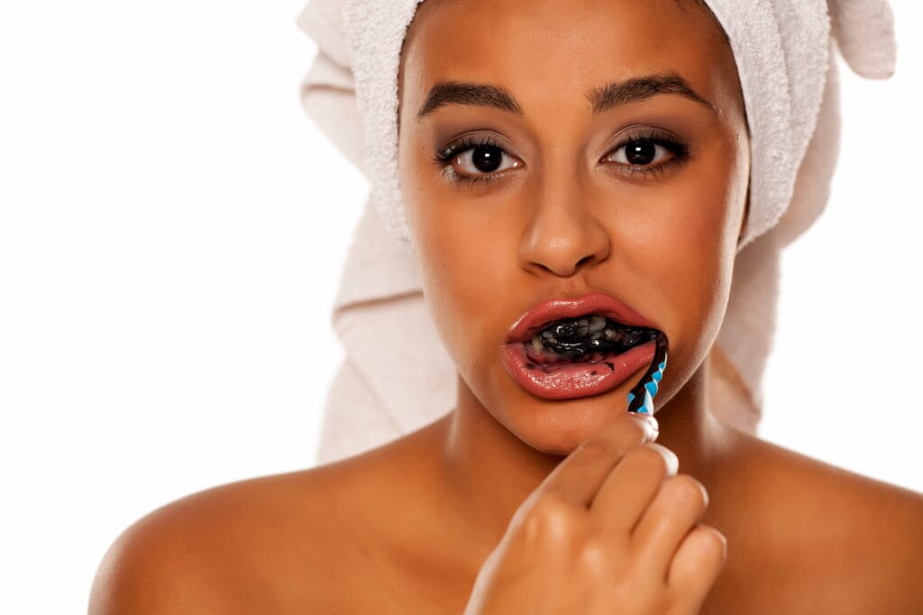 Woman wondering “Is charcoal toothpaste bad for your teeth?