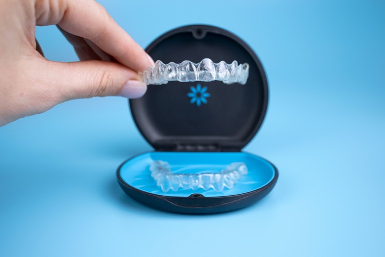 A woman holding her Invisliang retainer