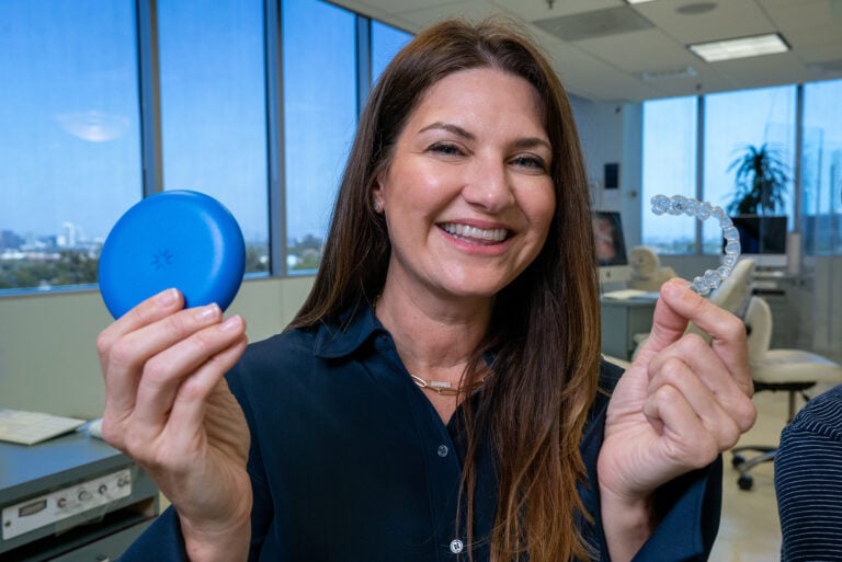 A woman shows off her Invisalign retainer