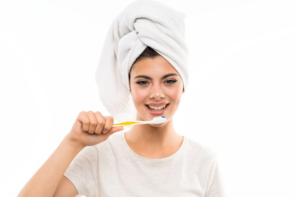 A woman shows off her gorgeous smile after taking care of them by using the best oral care routine.