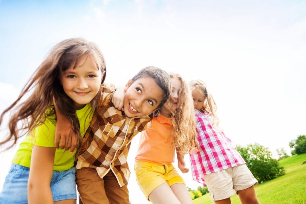 Children playing and smiling outside in the park