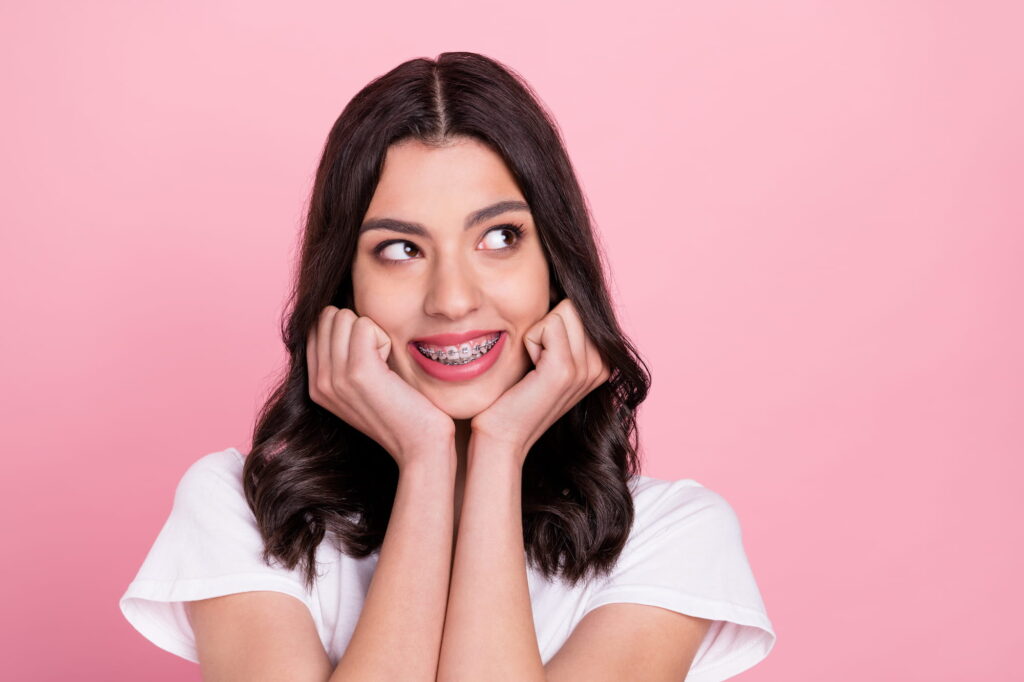 A young woman with braces shows off her improving smile.