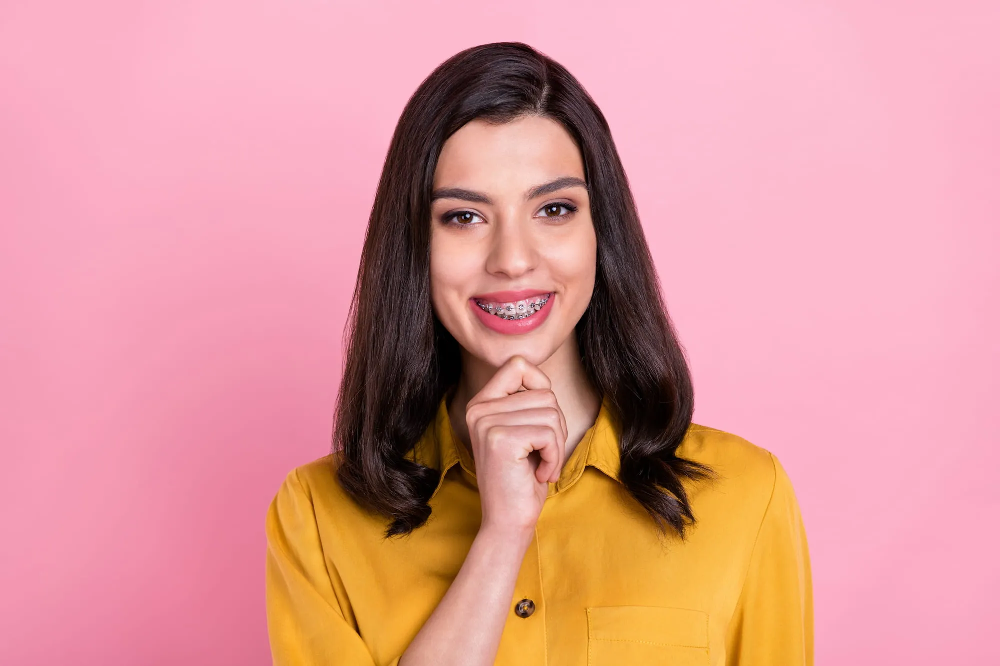 A woman shows off her braces and the sparkling smile behind them.